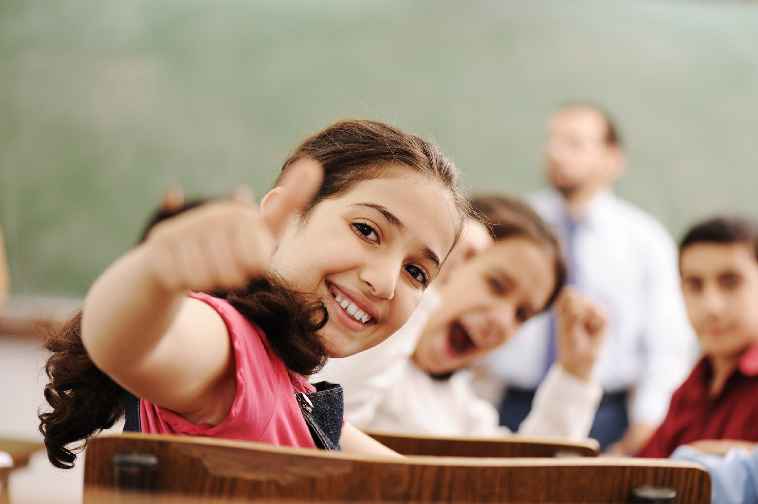 Happy,Children,Smiling,And,Laughing,In,The,Classroom,,Showing,Thumb